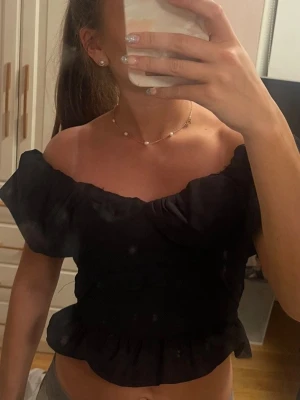 Svart offshoulder croppad topp - Snygg svart offshoulder topp med croppad passform och volangkant nedtill! Nytt skick💘💘