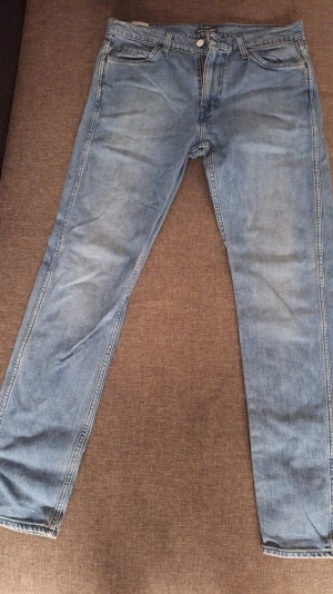 Ljusblå slim fit jeans - Snygga ljusblå slim fit jeans med klassisk femficksdesign och dragkedjegylf. Jeansen har en något tvättad look och raka ben. Perfekta för en avslappnad stil och lätta att matcha med olika outfits.