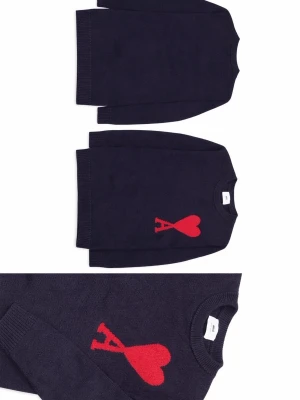 Mörkblå stickad tröja med rött hjärta från AMI  - Mörkblå stickad tröja från AMI med ett stort rött hjärta och bokstaven 'A' på bröstet. Tröjan har rund halsringning och ribbade muddar vid ärmslut och nederkant. Perfekt för dig som gillar stilrena plagg med en twist.