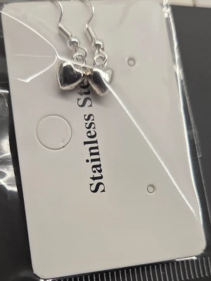 Silverfärgade hjärtörhängen i stål - Snygga örhängen i rostfritt stål med små blanka hjärtan som hänger på krok. Perfekta för dig som gillar stilrena och söta accessoarer. Hjärtana har en polerad finish som ger ett modernt intryck.