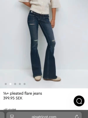 Mörkblå utsvängda jeans Gina Tricot - Säljer ett par mörkblå flare jeans från Gina Tricot med slitna detaljer vid knäna och klassiska fem fickor. Jeansen har hög midja och utsvängda ben för en trendig siluett. Tillverkade i denim med kontrastsömmar och dragkedjegylf.