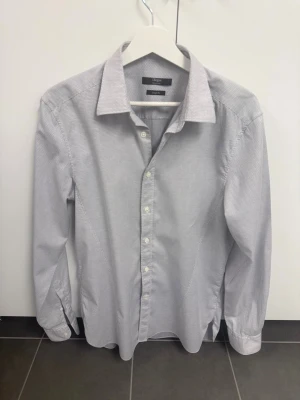 Gråmönstrad skjorta från Z Zegna - Snygg grå skjorta från Z Zegna Silver Line med diskret mönster och klassisk krage. Skjortan har lång ärm, knappar framtill och en stilren passform. Perfekt för dig som gillar en clean och modern look.