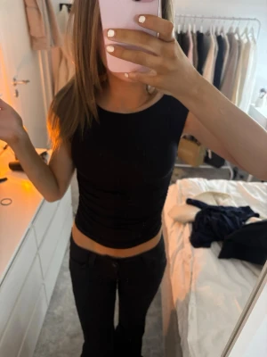 svart topp - unik svart topp med en kroppad passform. 