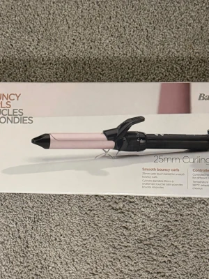 Locktång 25mm från BaByliss - Säljer en BaByliss locktång med 25mm cylinder i satin touch. Färgen är ljusrosa och svart, och tången har ett klassiskt grepphandtag. Perfekt för att fixa mjuka, studsiga lockar. Kommer i originalförpackning med tydliga instruktioner. Förpackad som ny