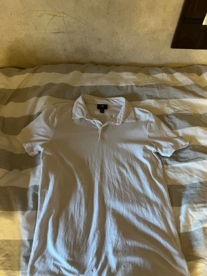 Vit slim fit piké från H&M - Säljer en stilren vit pikétröja från H&M i slim fit-modell. Skjortan har korta ärmar, klassisk krage och knappar vid halsen. Tillverkad i mjuk bomull som känns skön mot huden. Perfekt för dig som gillar en enkel och clean look. Ändast använd 1 gång köpt på hm för 190kr pris kan diskuteras.
