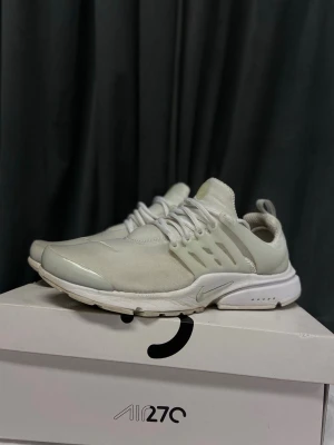 Nike presto - Snygga vita Nike Presto sneakers med mesh- och syntetmaterial, klassisk låg siluett och ikonisk swoosh på sidan. Skorna har vita snören, ventilerande ovandel och bekväm sula. Perfekta för dig som gillar stilrena och sportiga sneakers.
