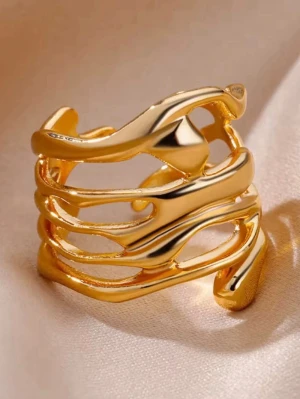 Guldfärgad vågig ring i metall - Trendig guldpläterad ring med vågiga, öppna former som ger en modern och unik look. Ringen har en bred design och glänsande finish som fångar ljuset snyggt. Perfekt för dig som vill sticka ut med dina accessoarer.