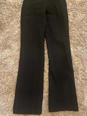 Svarta vida kostymbyxor - Snygga svarta kostymbyxor med hög midia och lös passform 