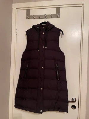 Lång svart dunväst med huva - ✨Snygg lång svart dunväst med huva och dragkedja framtill. Strl S men passar även en strl M✨