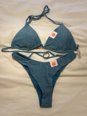 Glitterbikini - Sååå fin och snygg glittrig bikini men har aldrig kommit till användning tyvärr. Endast testad (med underkläder!!) prislapparna och skyddsplast kvar. Underdelen heter ”Even Higher” och överdelen heter ”Florida Top”, säljs hos Bik Bok fortfarande men inte i denna färg om man vill veta hur modellerna sitter. Underdel strl M och överdel strl L. True to size enligt mig.  Nypris 338kr för båda delarna