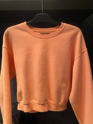 Persikofärgad cropped hoodie Bik Bok - Säljer en cropped hoodie från Bik Bok. Tröjan har rund halsringning, långa ärmar och ribbade muddar. Den är i ett mjukt sweatshirtmaterial som är riktigt skönt. Perfekt till våren och sommaren🌸