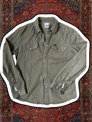 Lee jeans skjorta - En snygg grön Lee jeans skjorta, det står storlek L men passar mig som bär storlek M. Modellen är 183 cm lång och väger 73 kg