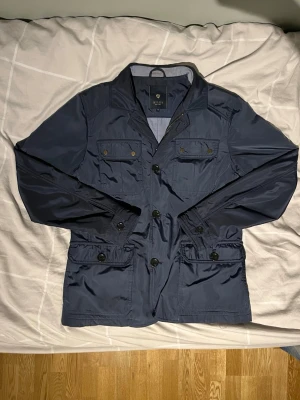 Riley Field Jacket - Snygg marinblå vindjacka från Riley med fyra framfickor och knappar. Skriv och ni har frågor och pris kan diskuteras🙌