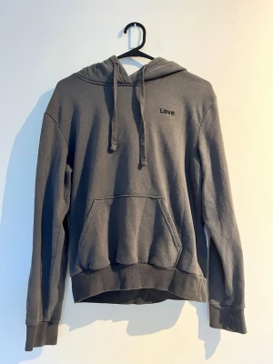 Mörkgrå hoodie - Mörkgrå hoodie med huva och dragsnören samt en stor magficka framtill. Storlek: XS