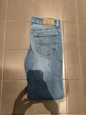 Blå Ralph lauren jeans - Klassiska blå jeans med rak passform och en enkel bakficka med diskret söm. Jeansen har normal midja och är tillverkade i denim. Perfekta för en avslappnad och stilren look.