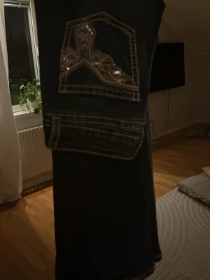 Mörkblå Gina Tricot jeans med brodyr - Säljer ett par mörkblå bootcut jeans från Gina Tricot i storlek 164. Jeansen har snygga broderade detaljer och dekorativa sömmar på bakfickorna. Klassisk femficksmodell i mjukt denimtyg, perfekta till din vardagsstil!! Snygga detaljer på bakfickorna❣️
