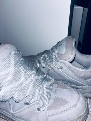 Vita chunky sneakers med meshdetaljer - Stilrena vita sneakers med chunky sula och breda skosnören. Ovandelen är i en mix av syntet och mesh för extra andningsförmåga. Perfekta för dig som gillar en clean och modern look. Passar till de flesta outfits och ger en sportig vibe.