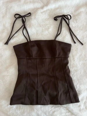 Brun topp med knytband - Snygg brun topp med tunna axelband som knyts i rosetter