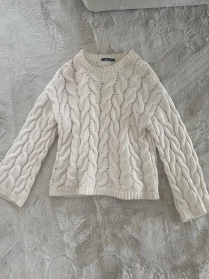 Vit kabelstickad tröja Gina Tricot - Säljer en krämvit kabelstickad tröja från Gina Tricot. Tröjan har rund halsringning, breda ärmar och ribbade muddar vid ärmslut och nederkant. 