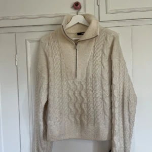 Krämvit stickad half zip tröja - Supermysig krämvit stickad tröja från Bik Bok med half zip och hög krage. Bra skick🤎