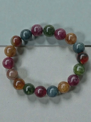 Färgglatt pärlarmband i sten - Snyggt armband med stora, runda pärlor i olika färger som grön, blå, rosa, gul och brun. Pärlorna är gjorda av polerad sten och sitter på en elastisk tråd. Perfekt för dig som gillar färg och vill ha något unikt på handleden.