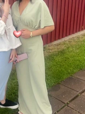 Ljusgrön långklänning med v-ringning - Snygg ljusgrön långklänning med v-ringad hals och korta ärmar. Klänningen har en avslappnad passform och är perfekt för varma dagar. Enkel och stilren design som passar till många tillfällen. Pris kan alltid diskuteras❤️