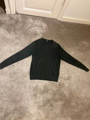 Mörkgrön stickad tröja Uniqlo - Säljer en stilren mörkgrön stickad merinoull tröja från Uniqlo. 100% MERINO