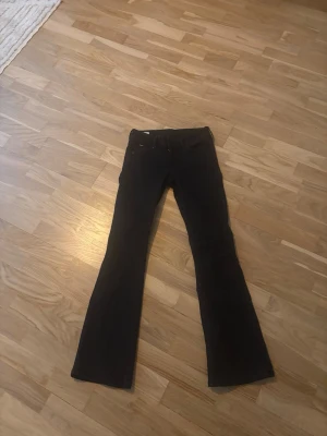 Svarta lågmidjade jeans från Pepe Jeans - Säljer ett par svarta flare jeans från Pepe Jeans. Jeansen har utsvängda ben och klassisk femficksdesign. Perfekta för dig som gillar en retroinspirerad look och vill ha något som sticker ut lite extra.