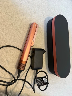 Dyson Airstrait - Säljer min nya Dyson Airstrait i färgen Amber Silk. Säljer den då jag knappast använder den. Har använt produkten ungefär 2 gånger bara. Säljs med matchande etui.  Ordinarie pris är 5730kr