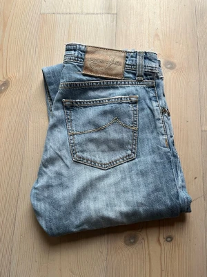 Jacob Cohën Jeans - Säljer nu dessa snygga Jacob Cohën jeans!  Den har färgen ljusblå, och har en snygg wash, vilket ger en riktigt stilig look till sommaren!  Storleken är 32, men jag skulle säga att den sitter som mellan 31 och 32 ungefär. Passformen sitter som slim.  Skicket är 8/10, endast slitna vid kanter, alltså längst ner vid benen, och och längst upp på midjan, som blir riktigt snyggt!  Nypriset är 4999kr❌ Mitt pris är 1299 kr✅  Om du har några frågor eller funderingar är det bara att fråga!
