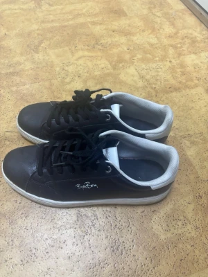 Svarta sneakers från Björn Borg - Svarta sneakers från Björn Borg med vita sulor och vit logga på sidan. Användes i ett tag men har ej hål eller liknande
