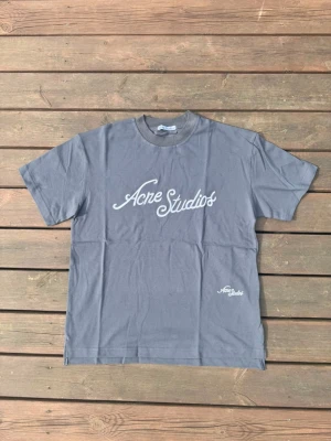 Acne Studios T-shirt  - Hej! Säljer en grå acne Studios T-shirt i storlek M. Har använt den ett fåtal gånger men är som ny. Den är äkta och inköpsbevis finns. Hör av dig vid frågor eller intresse!