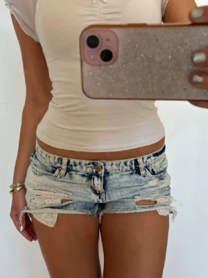 Lågmidjade shorts med spets  - Såå fina ljusblå slitna lågmidjade vintage jeansshorts med spets fickor! midjemått rakt över: 36. Jag är 168 och det är mina bilder, köp via köp nu direkt eller Swish, kvar tills markerad som såld 💖 