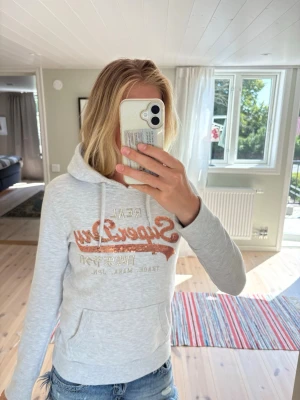 Superdry hoodie  - Superdry hoodie i storlek S (EU 36). Fint skick utan hål eller fläckar. Mjuk och skön med den klassiska Superdry-loggan i roséguldpaljetter.  Perfekt till svala sommarkvällar eller som en mysig hoodie året om. 🤍  📏 Storlek: S / EU 36 ✨ Skick: Mycket bra