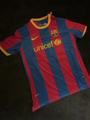 Barcelona matchtröja Nike blå/röd - Säljer en FC Barcelona matchtröja från Nike i blått och rött med gula detaljer. Tröjan har klubbmärke, UNICEF-logga och UEFA RESPECT-märke på ärmen. Tillverkad i lätt funktionsmaterial, perfekt för fotbollsträning eller match.