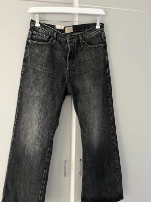 Svarta raka jeans från Jack & Jones - Säljer ett par svarta raka jeans från Jack & Jones med klassisk femficksmodell och knappgylf. Jeansen har en tvättad look med lätt slitna detaljer och är tillverkade i bomull. Perfekta för en avslappnad och trendig stil. ALDRIG ANVÄNDA,  jag fick min beställning idag och provade dem i bokstavligt 20 sekunder, jag märkte direkt att det inte var den stilen jag var ute efter. 