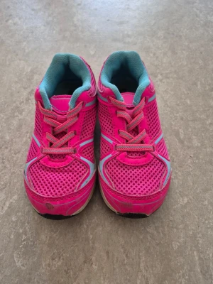 Sneakers - Snygga sneakers i starkt rosa med turkosa detaljer och mesh-tyg för bra ventilation. Skorna har vita och grå inslag samt klassisk snörning. Sulan är vit med turkosa partier. Perfekta för dig som vill sticka ut med färg på fötterna. Väl använda.