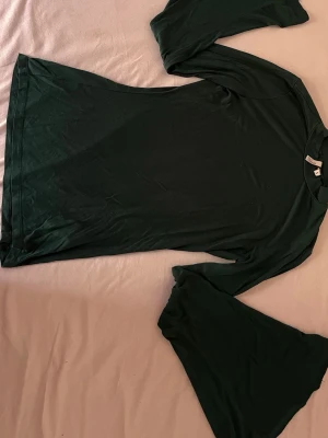 Mörkgrön långärmad topp NLY Trend - Mörkgrön långärmad topp från NLY Trend med rund halsringning. Tillverkad i mjukt material som känns bekvämt mot huden. Enkel och clean design som är lätt att styla till olika outfits.