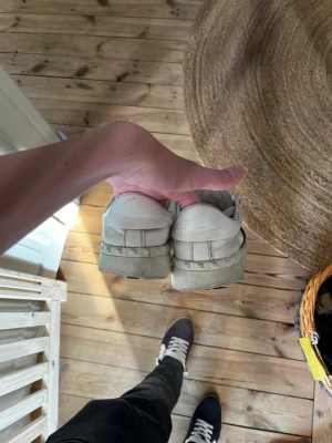Vita låga sneakers i läder - Säljer ett par klassiska vita sneakers i lågt snitt med enkel design. Skorna är tillverkade i läder och har en stilren look som passar till det mesta. Perfekta för dig som gillar minimalistisk stil och vill ha ett par tidlösa sneakers.