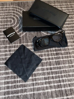 Chrome Hearts glasögon (anti blue light) - Snygga svarta solglasögon från Chrome Hearts med klassisk rektangulär form och silverdetaljer på skalmarna. Kommer med originalfodral, putsduk och garanti. Perfekta för dig som vill ha en stilren och exklusiv accessoar.