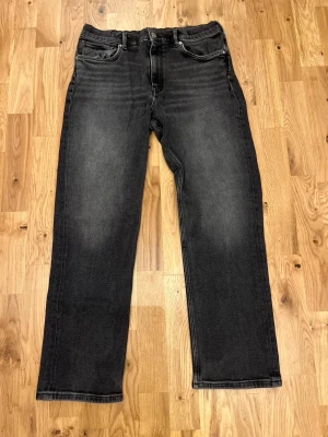 Svarta raka jeans med tvättad look från Gant - Snygga svarta jeans med rak passform och lätt tvättad effekt. Klassisk femficksmodell med normal midja och dragkedjegylf. Perfekta för en avslappnad och trendig stil.