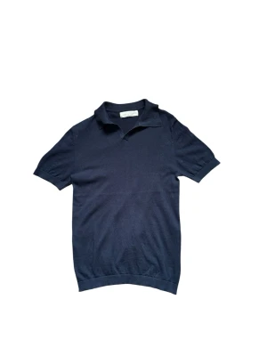 Sayless piké - Klassisk mörkblå pikétröja med krage och korta ärmar. Tröjan har en enkel och stilren design utan synliga loggor eller mönster, perfekt till jeans eller kjol. Mjuk och bekväm, passar till många olika looks.