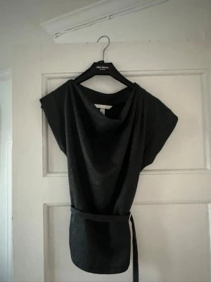 Grå topp med bälte från H&M - Grå topp från H&M. Inte använd tyvärr men väldigt skönt material 
