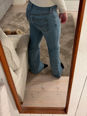 Bootcut lågmidjade jeans - Ljusblå lågmidjade jeans från levis som är i bra skick bortsätt från några små slitningar vid ena hälen. Storlek 25, tajta på mig som har s/m i byxor. 