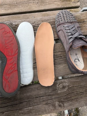 Gråa sneakers med nitar - Unika grå sneakers med matta nitar över hela tån och ovandelen. Skorna har snörning och är gjorda i mockaliknande material med beige innersula. Perfekt för dig som vill sticka ut med en edgy stil.
