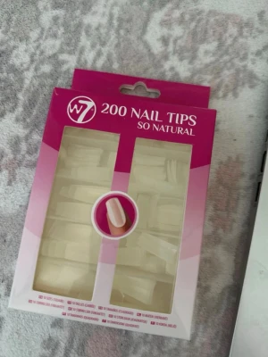 W7 200 Nail Tips helt ny 35kr - W7 200 Nail Tips So Natural är ett set med 200 press-on naglar i en naturlig ljus färg. Naglarna har en klassisk kvadratisk form och är tillverkade i syntetmaterial. Perfekt för dig som vill fixa snygga naglar snabbt och enkelt hemma.