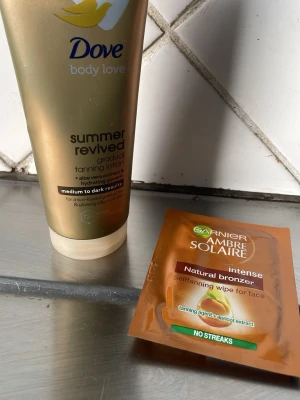 Brun utan sol-kit Dove & Garnier - Säljer ett kit med Dove Summer Revived gradual tanning lotion (medium to dark) och Garnier Ambre Solaire intense selftanning wipe för ansiktet. Perfekt för dig som vill ha en solkysst look året runt. Lotionen innehåller aloe vera och har återfuktande egenskaper.
