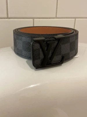 svart bälte - Snyggt svart bälte med rutiga mönster och svart logga, passar till alla clean outfits!