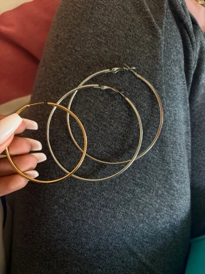 Stora hoops örhängen i guld och silver - Tre par stora hoops örhängen i metall, två i silverfärg och ett i guld. Klassisk rund form och enkel design som passar till många stilar. Perfekta för dig som gillar statement-smycken och vill ha något stilrent.