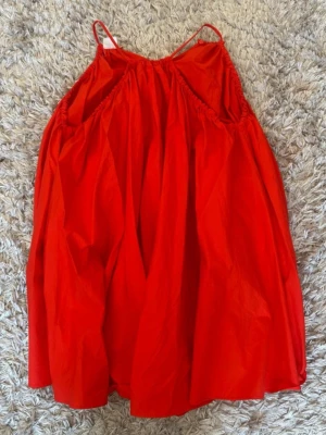 Röd sommarklänning från Zara - Snygg röd klänning från Zara med tunna axelband och luftig passform. Perfekt för varma dagar och enkel att styla med sneakers eller sandaler. Tillverkad i ett lätt material som känns skönt mot huden.